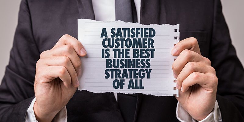 man holding sign with "a satsified customer" quote